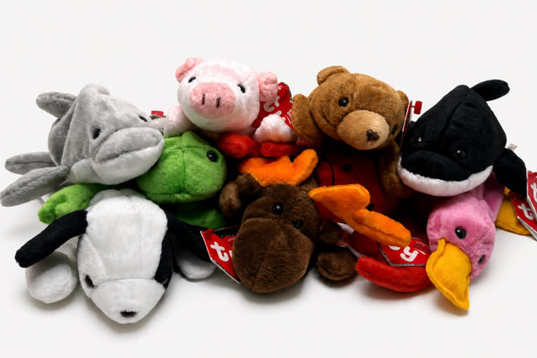 Nine Beanie Baby plush animals arranged together against a light gray studio background.