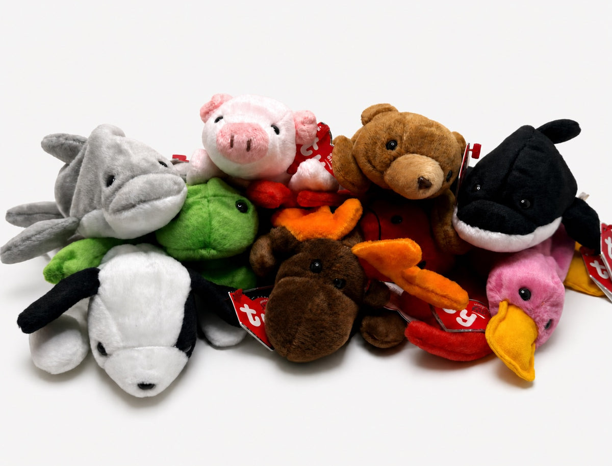 Nine Beanie Baby plush animals arranged together against a light gray studio background.