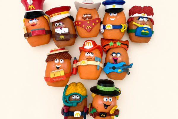 Ten 1988 McNugget Buddies in their snap-on costumes arranged on a cream background.
