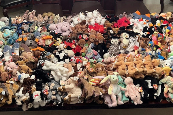 A large collection of Ty Beanie Babies arranged in rows, with many heart-shaped hang tags visible.