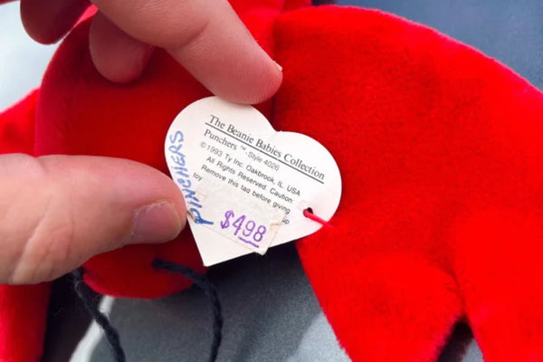 Close-up of a red lobster Beanie Baby with an early hang tag printed with the name Punchers.