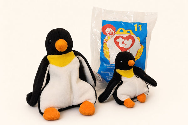 Full-size Waddle the Penguin Beanie Baby next to the much smaller McDonald's Teenie Waddle and its numbered Happy Meal bag