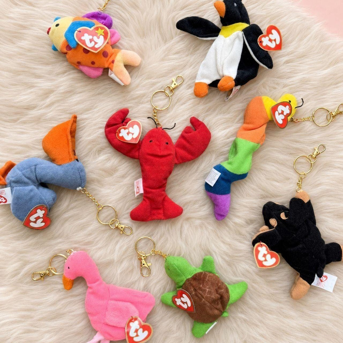 Teenie Beanie Baby bag charms by Millennial Daydreams, laid out on a fur throw