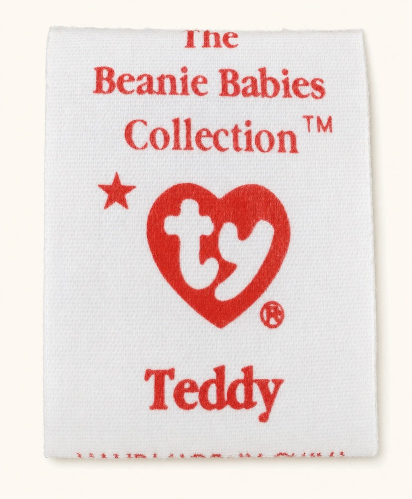 A 4th generation tush tag from Teddy, with a small red star beside the upper left of the Ty heart logo.
